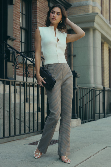 Image of woman in white vest and check pants.